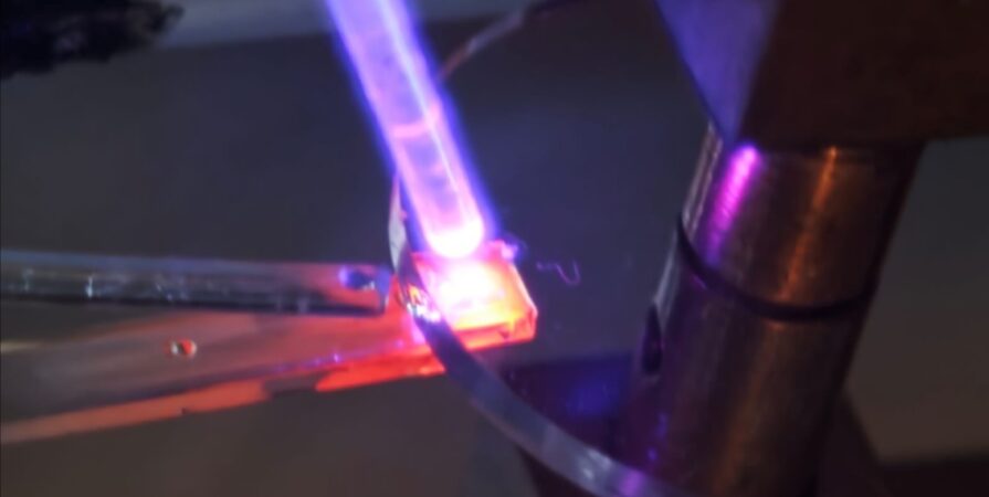 close up of a material glowing red under a blue laser
