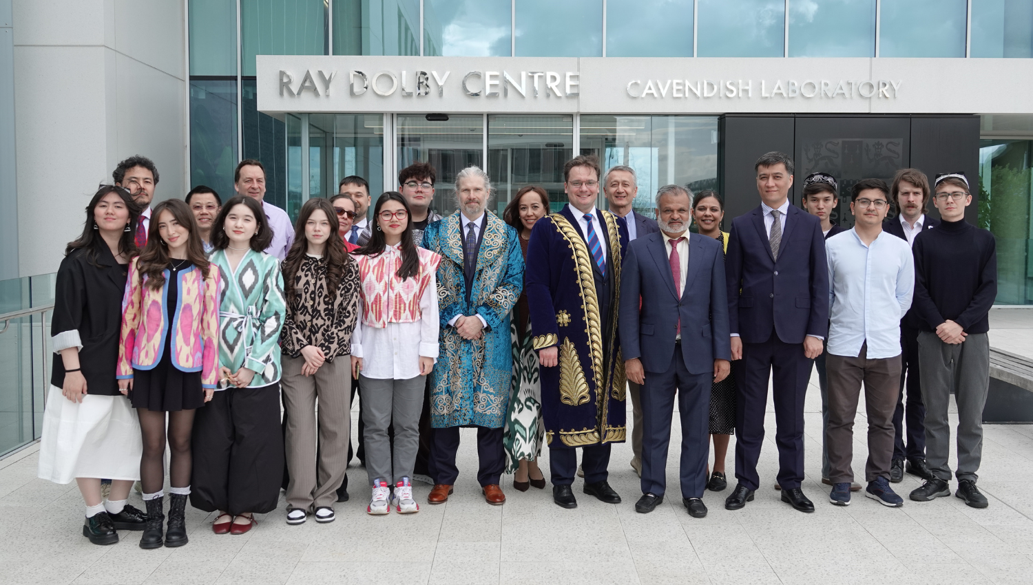 group photo outside the Ray Dolby Centre, Cavendish Laboratory, Some members are wearing traditional Uzbek outfits. 